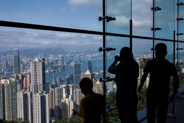 Tourists take photos in front of the financial Central district and Victoria Harbour in Hong Kong, China, May 9, 2023. REUTERS/Tyrone Siu/File Photo