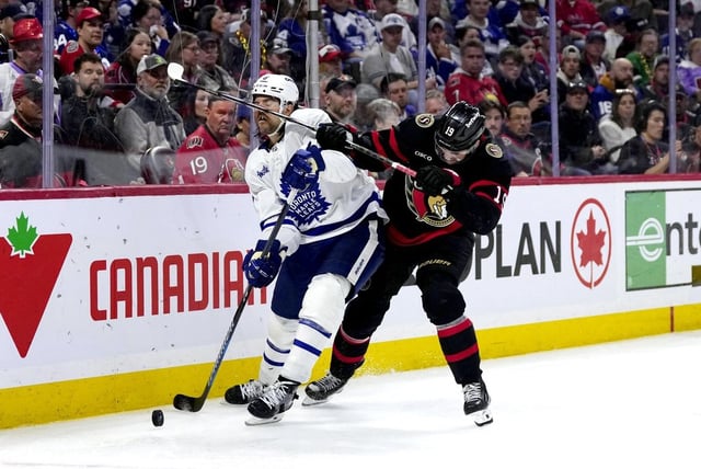 Ottawa Senators' Drake Batherson (19) gets his stick in the face of Toronto Maple Leafs' Chris Tanev (8) during overtime NHL playoff action in Ottawa, on Saturday, April 26, 2025. THE CANADIAN PRESS/Justin Tang
