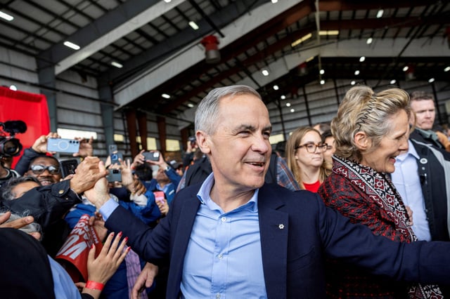 Canada's Prime Minister Mark Carney interacts with supporters, next to his wife Diana Fox Carney, at a rally in a Pearson International Airport hangar, during his Liberal Party election campaign tour in Mississauga, Ontario, Canada April 26, 2025. REUTERS/Carlos Osorio/File Photo