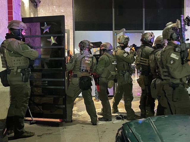 DEA police enter the club after driving out the nearly 200 patrons who had been inside at 3:45 a.m. MT.