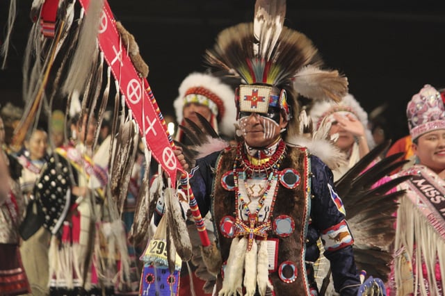 CORRECTS DATE - The grand entry of hundreds of Native American and Indigenous dancers begins with the staff procession during the annual Gathering of Nations powwow in Albuquerque, New Mexico, on Friday, April 25, 2025. (AP Photo/Susan Montoya Bryan)