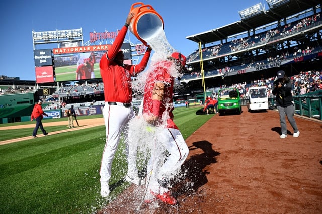 Washington Nationals’ Josh Bell, left, douses Luis Garcia Jr., right, after a baseball game against the New York Mets, Sunday, April 27, 2025, in Washington. (AP Photo/Nick Wass)