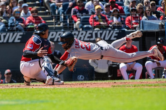 Boston Red Sox’s Kristian Campbell, right, scores on a throwing error as Cleveland Guardians’ Bo Naylor, left, is late with the tag during the second inning of a baseball game Sunday, April 27, 2025, in Cleveland. (AP Photo/Phil Long)