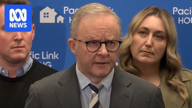 Close up of Anthony Albanese in grey suit with man and woman behind him