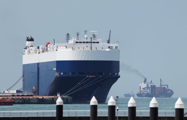 A container ship passes a car cargo ship at a port terminal in Singapore February 20, 2025. REUTERS/Edgar Su