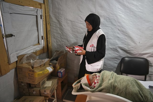 Doctors weigh a Palestinian baby at the Médecins Sans Frontières (MSF) clinic in Muwasi, near Khan Younis in the southern Gaza Strip, Wednesday, April 9, 2025. (AP Photo/Abdel Kareem Hana)