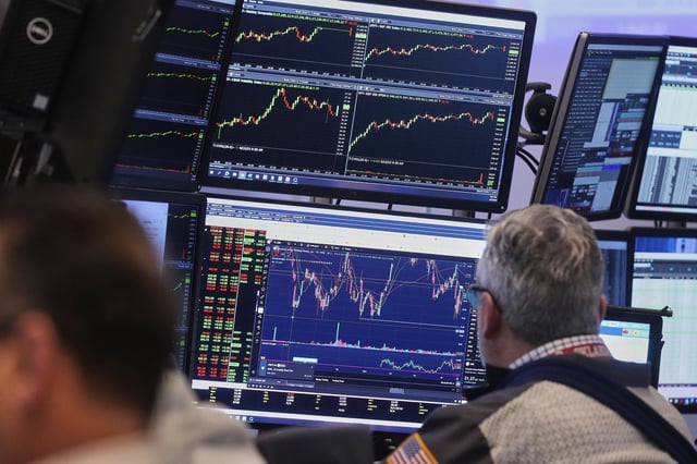 A trader works on the floor of the New York Stock Exchange, Friday, April 25, 2025. (AP Photo/Richard Drew)