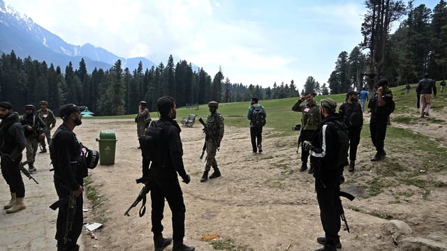 Security personnel inspect the site in the aftermath of an attack as food stall chairs lie empty in Pahalgam.