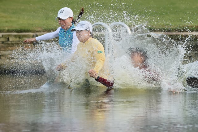 Mao Saigo of Japan (C) jumps in the pond on the 18th hole after winning The Chevron Championship 2025 in a playoff at The Club at Carlton Woods on April 27, 2025