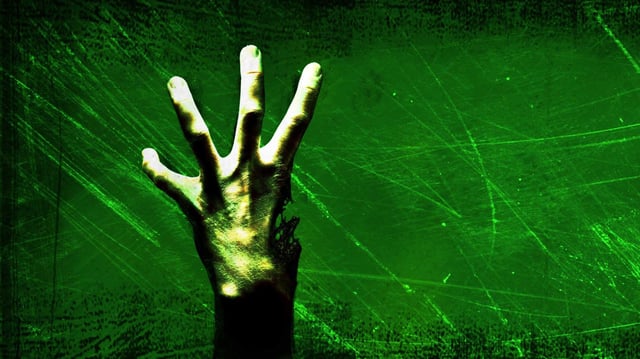 A zombie hand missing a thumb rises into view