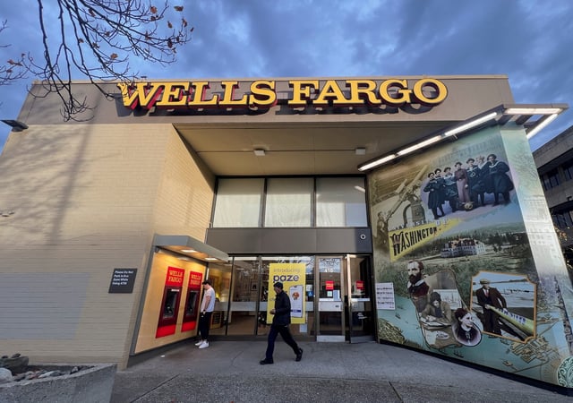 A man walks from a branch of Wells Fargo bank in the University District of Seattle, Washington, U.S. December 6, 2024. REUTERS/Chris Helgren/File Photo
