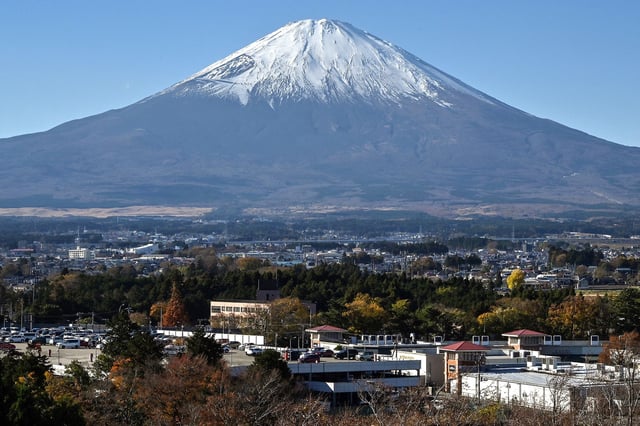 This photo taken on November 28, 2024 shows Mount Fuji pictured behind the city of Gotemba, Shizuoka prefecture, some 100 kms southwest of Tokyo. (Photo by Richard A. Brooks / AFP) (Photo by RICHARD A. BROOKS/AFP via Getty Images)
