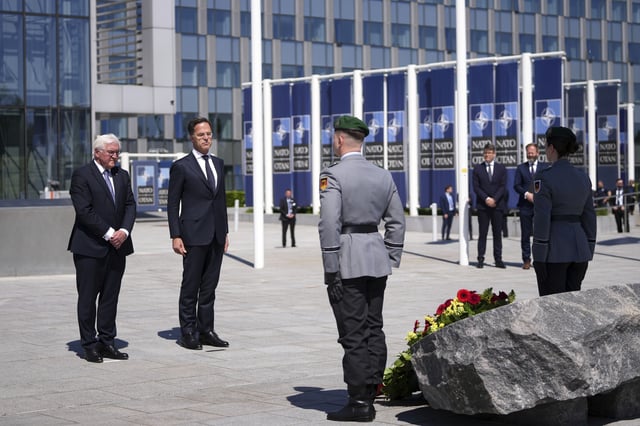 Germany's President Frank-Walter Steinmeier, left, and NATO Secretary General Mark Rutte, center, participate in a wreath laying ceremony to mark the 70th anniversary of Germany's accession to NATO at NATO headquarters in Brussels, Monday, April 28, 2025. (AP Photo/Virginia Mayo)