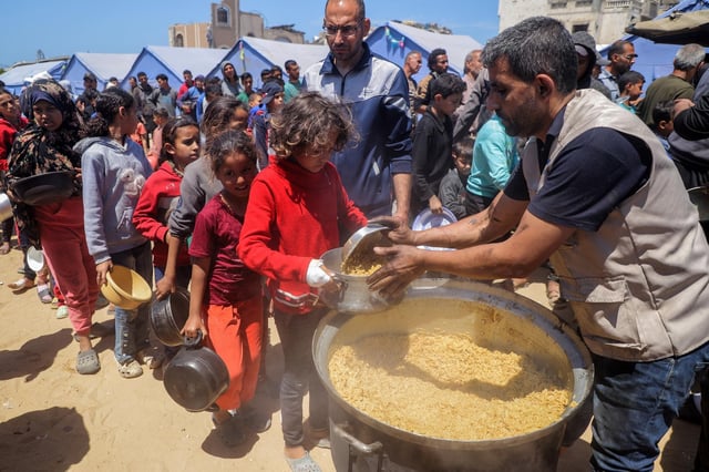 Un enfant palestinien reçoit de la nourriture d’un centre de distribution alimentaire dans la ville de Gaza, le 19 avril 2025.