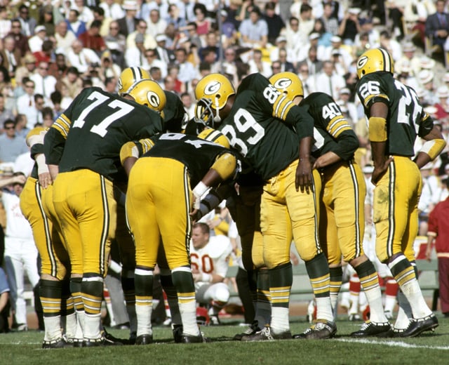 The Green Bay Packers defense--including Tom Brown (40), Hall of Famers Willie Davis (87) and Herb Adderley (26)--huddle up during Super Bowl I, a 35-10 victory over the Kansas City Chiefs on January 15, 1967, at the Los Angeles Memorial Coliseum.