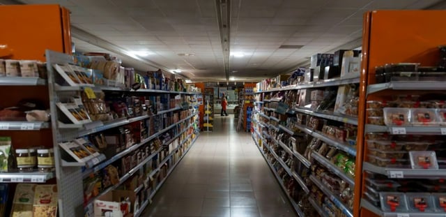 AFP - Un employé se tient à l'intérieur d'un supermarch" plongé dans le noir à Burgos, le 28 avril 2025 alors que la péninsule ibérique est affectée par une panné géante d'électricité
