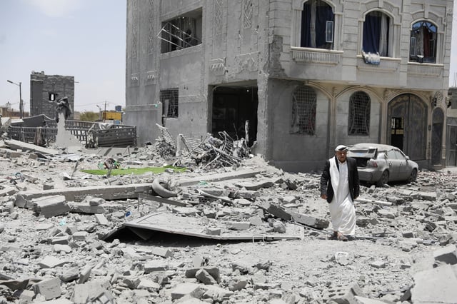 A man walks on the rubble of a building destroyed by U.S. air strikes in Sanaa, Yemen April 27, 2025. REUTERS/Khaled Abdullah