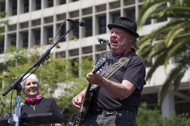 Neil Young performs as he is joined by Joan Baez during a &#34;Fighting Oligarchy&#34; event with Sen. Bernie Sanders, I-Vt., and Rep. Alexandria Ocasio-Cortez, D-N.Y., in Los Angeles on April 12. Over the weekend, Young debuted a politically charged new song at a benefit concert in Los Angeles to deliver pointed criticism of President Donald Trump, Elon Musk and his electric vehicle company Tesla.