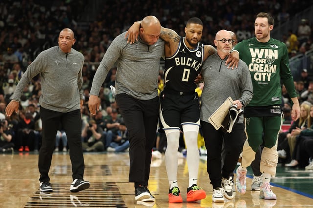 Damian Lillard #0 of the Milwaukee Bucks is helped off the court after an apparent injury during the first quarter in Game Four of the Eastern Conference First Round NBA Playoffs against the Indiana Pacers at Fiserv Forum on April 27, 2025 in Milwaukee, Wisconsin.