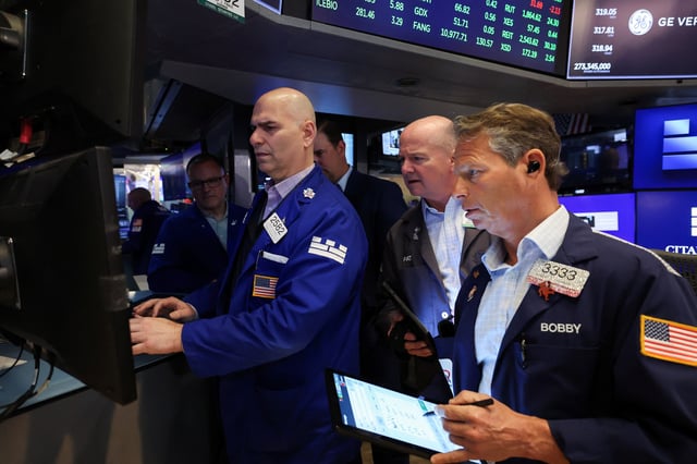 Traders work on the floor at the New York Stock Exchange (NYSE) in New York City, U.S., April 22, 2025. REUTERS/Brendan McDermid