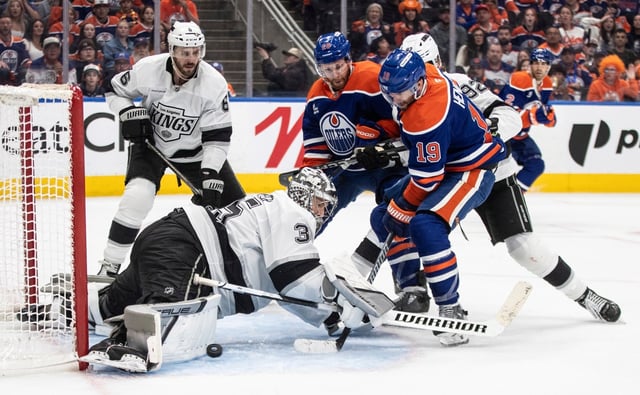 Kings goaltender Darcy Kuemper, left, makes a save on a shot by the Edmonton Oilers’ Adam Henrique (19) during the overtime portion of Game 4 of their first-round playoff series on Sunday night in Edmonton, Alberta. The Kings lost, 4-3, as the Oilers knotted the best-of-seven series at 2-2. (Jason Franson/The Canadian Press via AP)