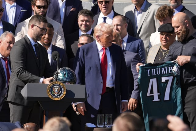 Apr 28, 2025; Washington, DC, USA; Philadelphia Eagles’ head coach Nick Sirianni, left, and offensive tackle Lane Johnson stand next to President Donald Trump as he honors the Super Bowl LIX champion Philadelphia Eagles at The White House in Washington D.C., on April 28, 2025. Mandatory Credit: Josh Morgan-USA TODAY via Imagn Images