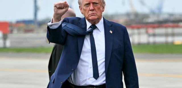 Le président américain Donald Trump lève le poing alors qu'il descend de l'Air Force One à son arrivée à l'aéroport international de Newark Liberty à Newark, New Jersey, le 26 avril 2025