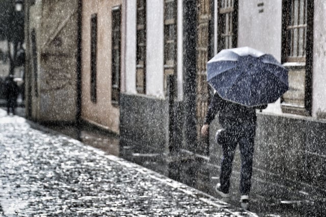 Persona protegiéndose de la lluvia con un paraguas.