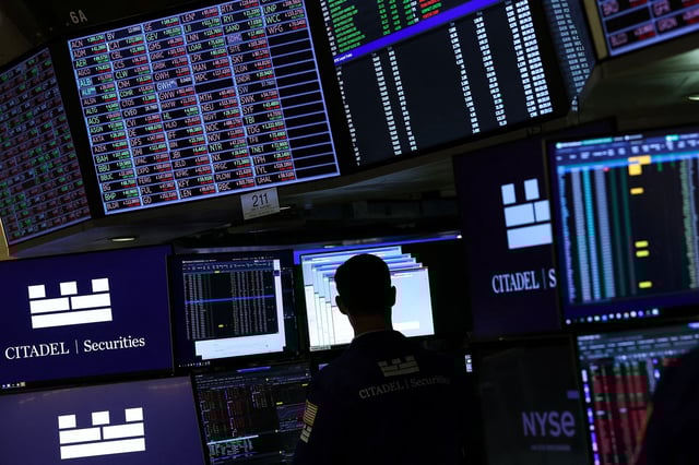 Traders work on the floor of the New York Stock Exchange at the opening bell on April 9.