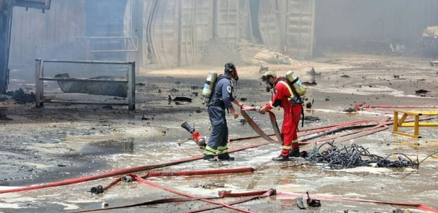 Photo fournie par le Croissant-Rouge iranien (IRCS), le 28 avril 2025, de pompiers sur les lieux d'une explosion massive deux jours plus tôt dans le port Shahid Rajaï, dans la province d'Hormozgan, en Iran