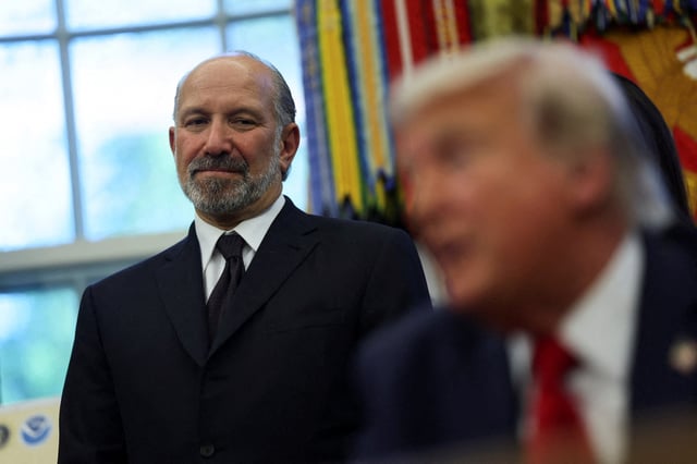 U.S. Secretary of Commerce Howard Lutnick listens to U.S. President Donald Trump speak during an even to to sign executive orders in the Oval Office at the White House in Washington, D.C., U.S., April 23, 2025. REUTERS/Leah Millis