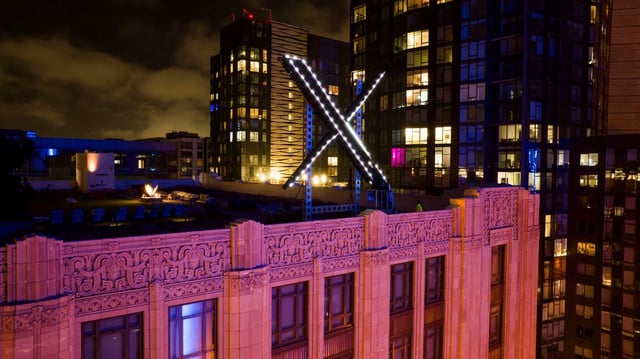 FILE - Workers install lighting on an &#34;X&#34; sign atop the company headquarters, formerly known as Twitter, in downtown San Francisco, July 28, 2023. (AP Photo/Noah Berger, File)