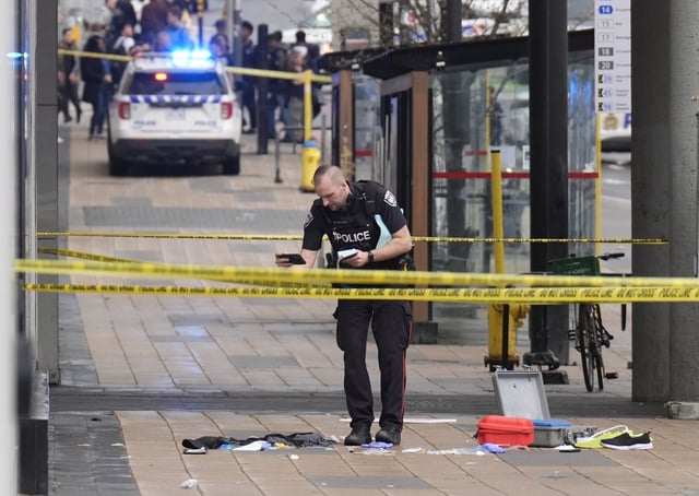 A police officer takes pictures of a crime scene following an officer-involved shooting in Ottawa on Tuesday, April 29, 2025. THE CANADIAN PRESS/Adrian Wyld