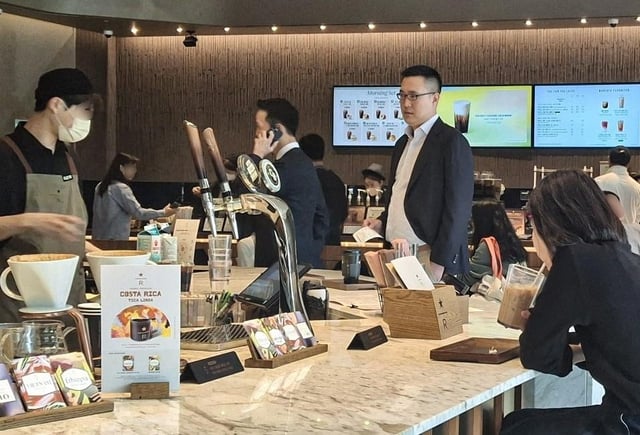 This photo, taken April 30, 2025, shows Kim Dong-won (3rd from L), chief global officer and president of Hanwha Life Corp., on a phone call, and Kim Dong-seon (4th from L), vice president and head of future vision at Hanwha Galleria Corp., waiting for a coffee order at a coffee shop in Josun Palace hotel in southern Seoul. The two were seen following their suspected meeting with Donald Trump Jr. to discuss potential business partnerships during his two-day visit to South Korea. (Yonhap)