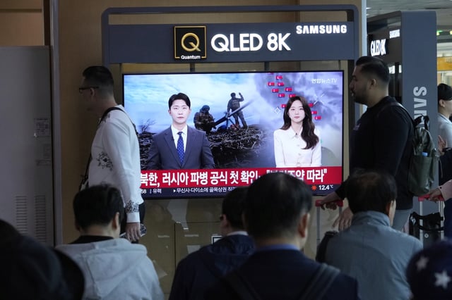 People pass by a TV screen reporting North Korea confirms troops deployment to Russia during a news program at the Seoul Railway Station in Seoul, South Korea, Monday, April 28, 2025.(AP Photo/Ahn Young-joon)