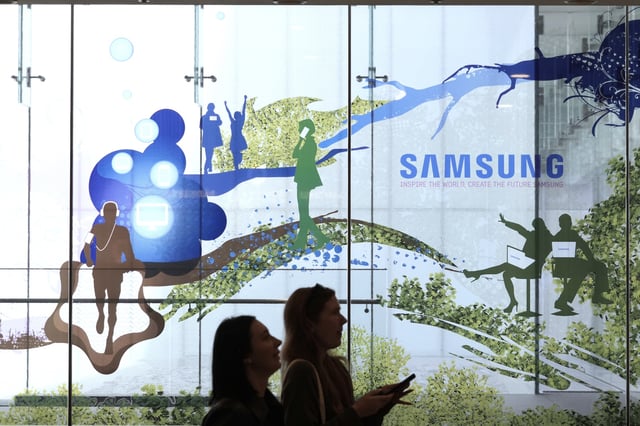 Visitors walk past the logo of the Samsung Electronics Co. at its office in Seoul, South Korea, Tuesday, April 29, 2025. (AP Photo/Ahn Young-joon)
