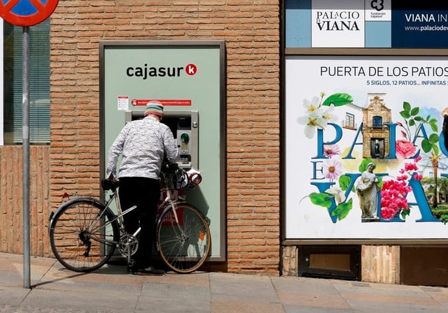 Una persona hace una gestión en un cajero de la ciudad