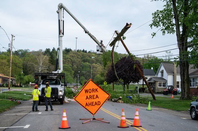 A crew works to remove a tree from a power pole in in Gnadenhutten, Ohio, after severe thunderstorms Tuesday.