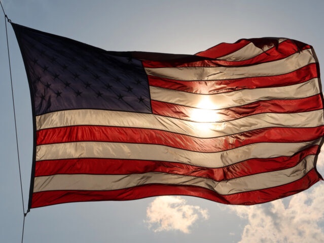 HOBOKEN, NJ - MAY 15: The sun sets behind an American Flag on May 14, 2020 in Hoboken, New Jersey. (Photo by Gary Hershorn/Getty Images)