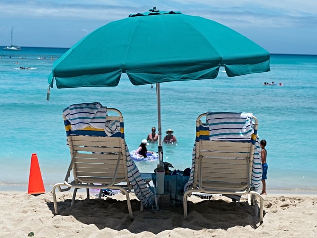 Two beach chairs are visible under an umbrella at Waikiki Beac, island of Oahu, Honolulu, Hawaii, July 24, 2024. (Photo by Smith Collection/Gado/Getty Images)