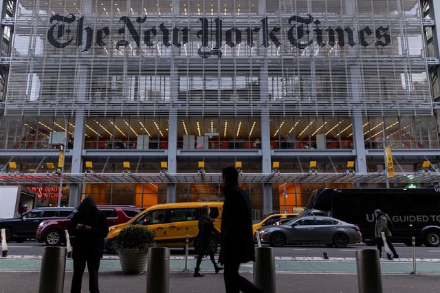 Pedestrians walk by the New York Times building in Manhattan, New York, in December 2022.