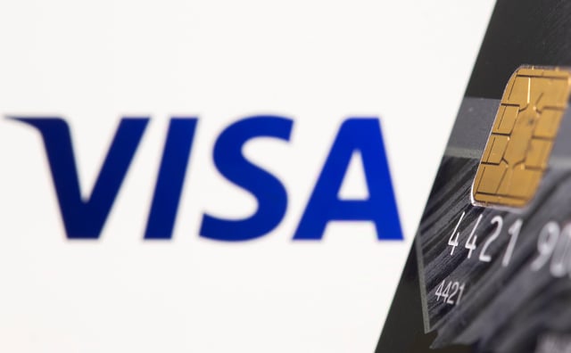 Credit card is seen in front of displayed Visa logo in this illustration taken, July 15, 2021. REUTERS/Dado Ruvic/Illustration