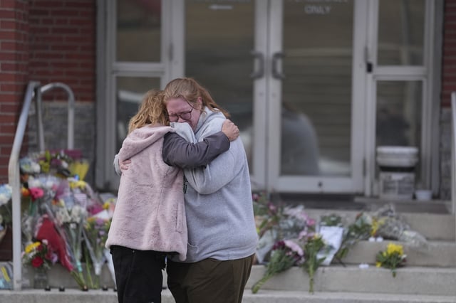 FILE - Leah Fauth gets a hug after leaving flowers in front of the West York Police Department after a police officer was killed responding to a shooting at UPMC Memorial Hospital in York, Pa., Feb. 22, 2025. (AP Photo/Matt Rourke, File)