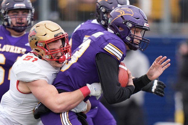 Laurier Golden Hawks' Taylor Elgersma (13) is tackled by Laval University Rouge et Or's Loic Brodeur (51) during U Sports Vanier Cup first half football action in Kingston, Ontario on Saturday, Nov. 23, 2024.  The Winnipeg Blue Bombers drafted Elgersma in the second round of the CFL draft on Tuesday night.




