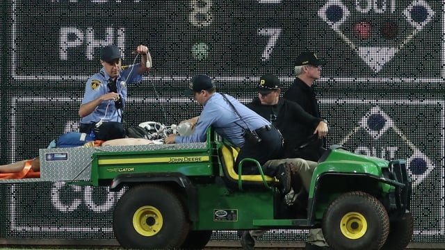 Stadium security and Pittsburgh Pirates medical personnel cart a fan who fell from the stands to the field to an ambulance 