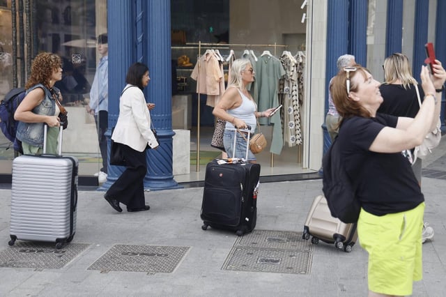 Viajeros con maletas por el centro de València, este abril.