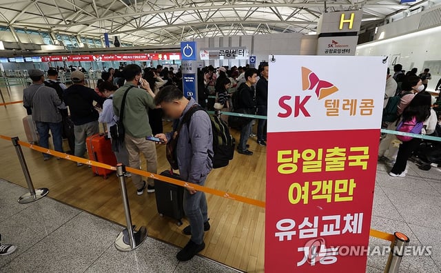 Outbound travelers wait in line at an outlet of SK Telecom Co., South Korea's leading mobile carrier, inside Incheon airport, west of Seoul, on May 1, 2025, to have a free universal subscriber identity module (USIM) replaced on their smartphones following a network hacking incident involving the potential leak of subscriber information. (Yonhap)