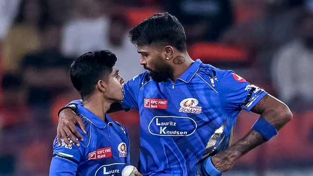 Mumbai Indians' captain Hardik Pandya (R) speaks with Vignesh Puthur