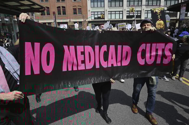 File photo: protestors holding a Medicaid sign.
