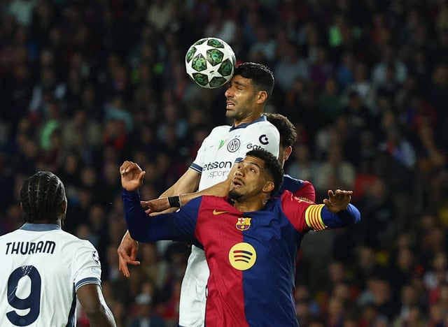Soccer Football - Champions League - Semi Final - First Leg - FC Barcelona v Inter Milan - Estadi Olimpic Lluis Companys, Barcelona, Spain - April 30, 2025 Inter Milan's Mehdi Taremi in action with FC Barcelona's Ronald Araujo REUTERS/Albert Gea